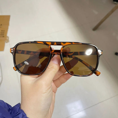 Vintage Men Women Big Sunglasses Men Square Shades Brand Designer Unisex Sun Glasses Black Lense Male Female Sunglasses UV400 held by hand, featuring tortoiseshell frame and brown lenses in a modern indoor setting.