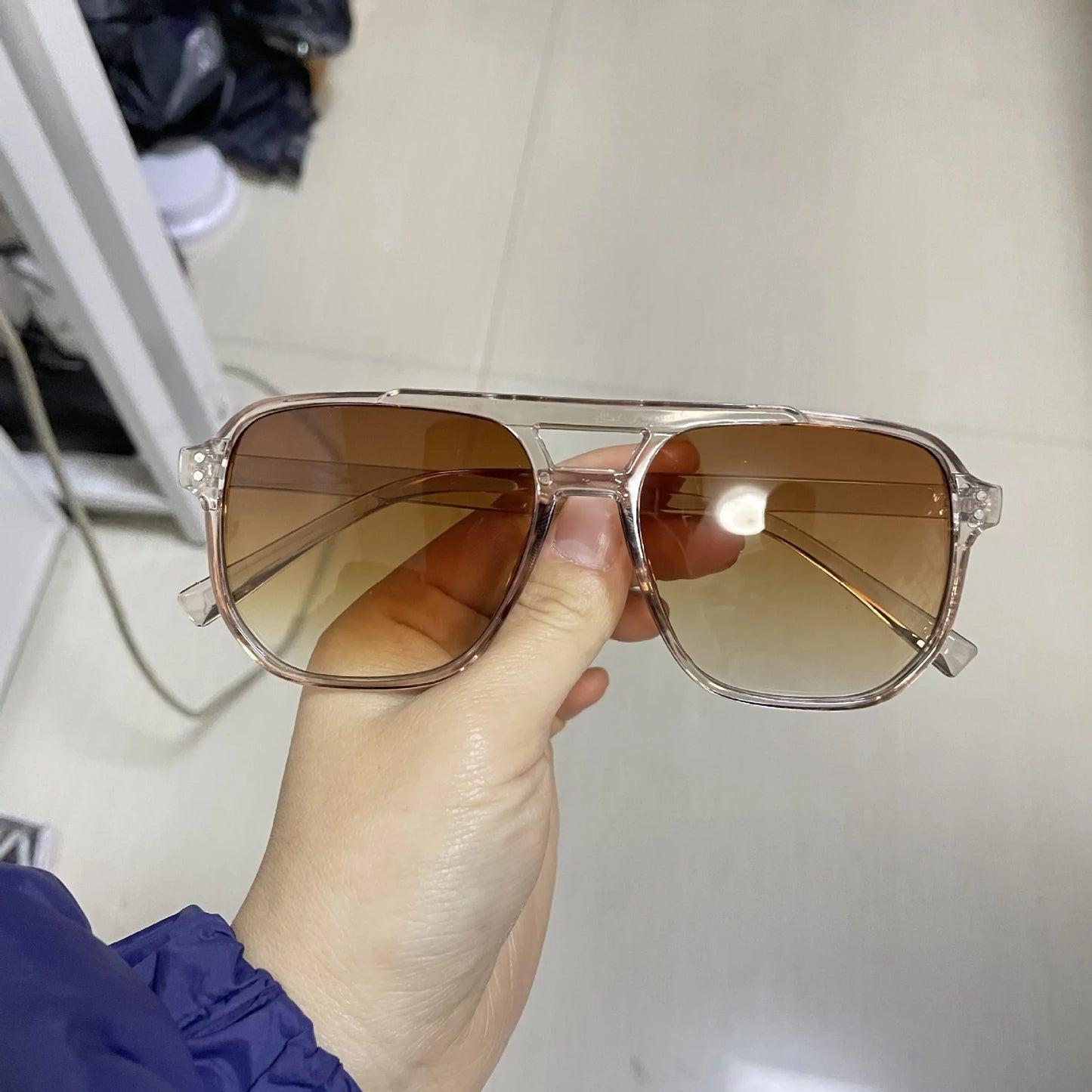 Vintage Men Women Big Sunglasses Men Square Shades Brand Designer Unisex Sun Glasses Black Lense Male Female Sunglasses UV400 held by hand with transparent frame and brown gradient lenses for men’s and women’s styles.